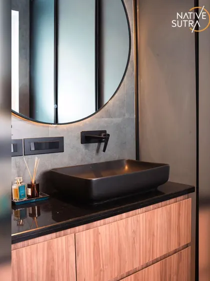 A close-up of the matte black vessel sink and wall-mounted faucet. These details contribute to the bathroom's sleek, modern, and industrial aesthetic.