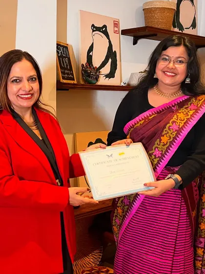 A winner dressed in traditional attire receives her certificate, representing the beautiful diversity of our participants.