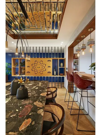 A close-up of the dining area, highlighting the intricate detail of the puja unit screen and the beautiful, complex pattern of the marble tabletop.