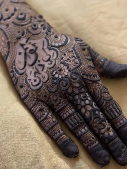 A close-up of a name written in beautiful Arabic calligraphy, serving as the centerpiece of the palm design.