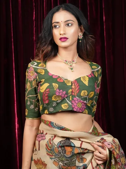 This model showcases a full Kalamkari look, with a floral print blouse and a matching saree. The simple stone necklace she wears complements the busy print without overwhelming it.