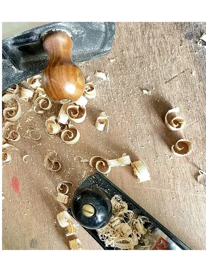 The beautiful curls of wood shavings, known as "spills," created by a sharp hand plane. This is one of the most satisfying sights in woodworking.