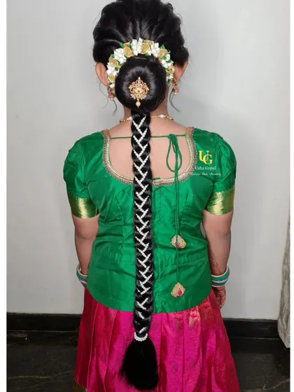 A traditional South Indian hairstyle for my young client, Poorvi. This features a neat bun covered in fresh flowers (gajra) and a long, decorated braid, making her look like a little princess.