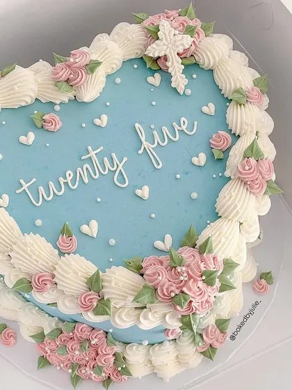 A beautiful heart-shaped cake in a vintage Lambeth style, with intricate hand-piped borders and delicate pink roses.