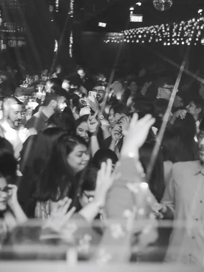A black and white shot of the dance floor, capturing a timeless moment of collective celebration. The energy is just as powerful without color.