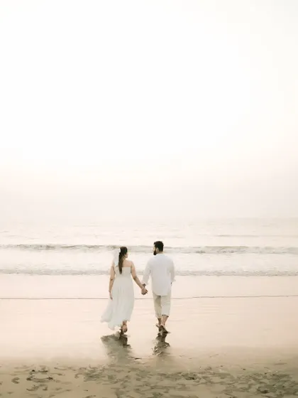 Walking towards the ocean, hand in hand. A classic romantic shot that symbolizes the journey you're taking together.