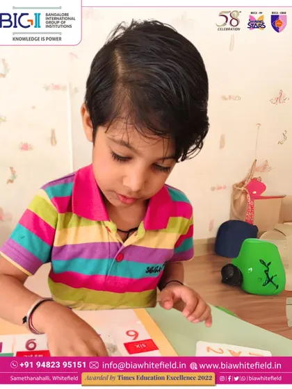 A student carefully places number tiles, engaging in a hands-on math game. We make learning an adventure for our little explorers.