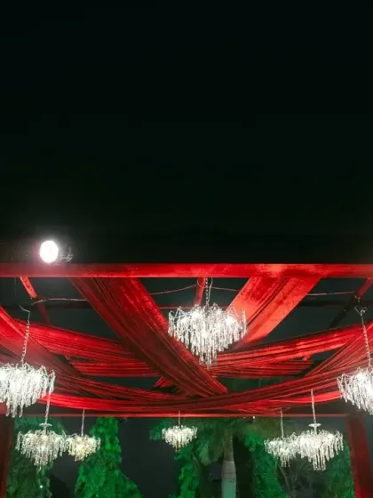 A grand statement with red drapes and crystal chandeliers. This ceiling treatment for a Broadway-themed Sangeet adds a touch of glamour and theatricality to the space.