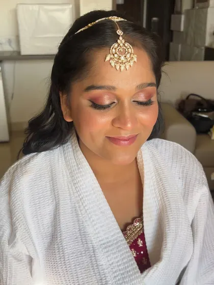 A close-up of the bridesmaid's makeup, featuring soft, shimmery rose-gold eyes and a glowing complexion.