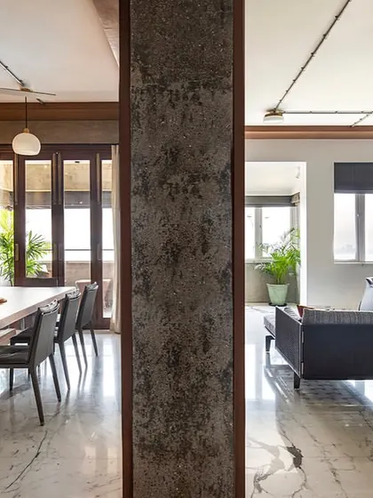 This image captures the essence of our open-plan design philosophy. The living and dining areas of 'The Canvas' apartment flow into one another, separated only by a raw concrete column, creating a unified space that is perfect for both family life and entertaining.