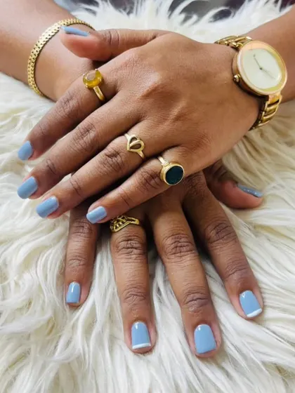 A chic and trendy look with a dusty blue gel polish on short, natural nails, featuring a minimal white tip on the index finger.