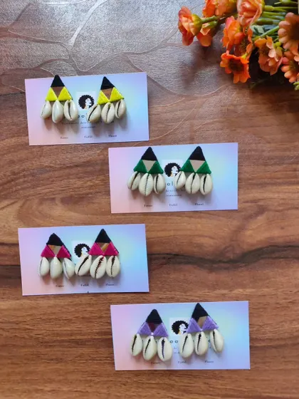 These fun and bohemian shell earrings, also known as kodi earrings, are perfect for a beachy or festive look. They are available in yellow, green, pink, and purple.