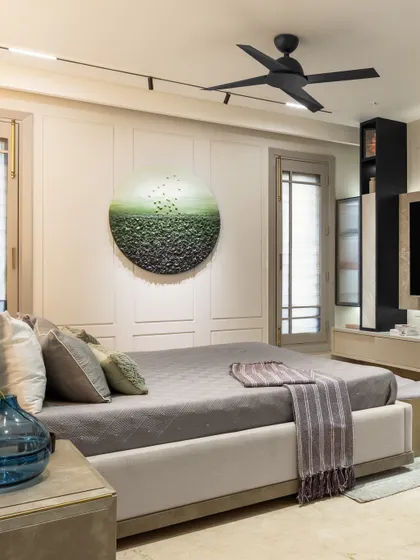 An overall view of the master bedroom, showing the balance between the serene color palette and the functional layout. The design includes a sleek TV unit and ample natural light, creating a bright and airy feel.