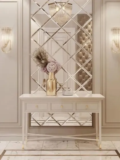 An elegant entryway featuring wall molding and a large, decorative mirror made of beveled glass pieces. The classic console table completes this sophisticated look.