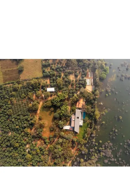 An aerial drone shot captures the vast 50 acre site of the Lakeshore house. The home is a small, respectful intervention in a wild landscape of trees, rocks, and water.