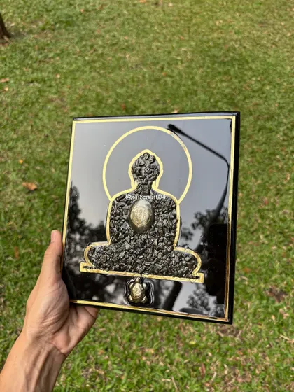 A handheld view of the Mahaveer Swami artwork, showing its size and the beautiful contrast between the black resin and the golden details.