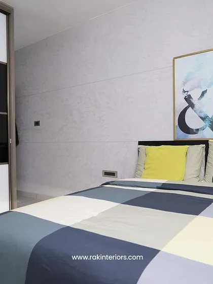 A modern bedroom with a bold, graphic-patterned duvet. The black and white sliding wardrobe provides ample storage while maintaining a sleek and contemporary look.