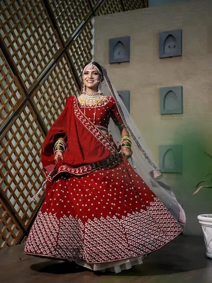 A full-length shot of the bride twirling, her red lehenga in full motion. This dynamic portrait is full of energy and happiness.