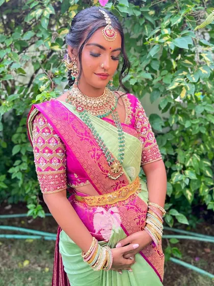 A bride channeling Barbiecore vibes in a pink zardosi blouse with geometric shapes on the sleeves.