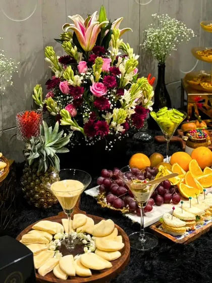A stunning grazing table laden with cheeses, fresh fruits, crackers, and floral arrangements. This type of spread is perfect for cocktail hours and networking events, encouraging guests to mingle.