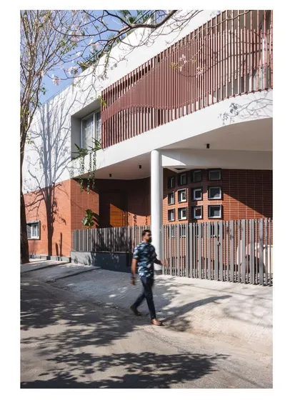 The ground floor of the 'House Under Tabebuia Trees' is designed to be open and accessible, with a clear view of the street and the surrounding greenery.