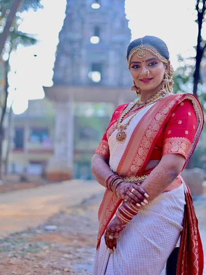 A portrait of the bride standing gracefully with a temple in the background. This image combines traditional attire with a culturally significant setting.