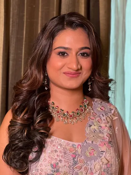 A close-up portrait of Vini, her makeup perfectly complementing the soft colors of her outfit.
