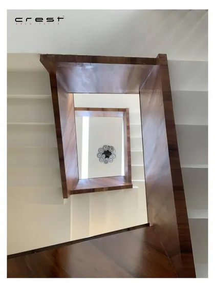 A view looking up through the 'Framed House' staircase, creating a spiraling, geometric pattern with the wood-clad handrails.