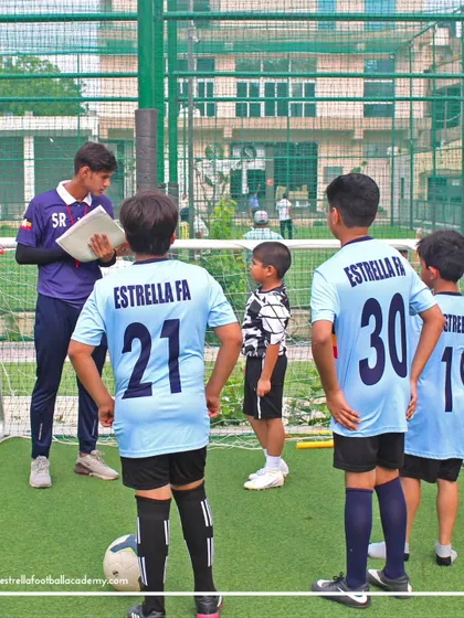A coach giving tactical instructions to his team. This close interaction ensures that players not only learn drills but also understand the strategic side of football.