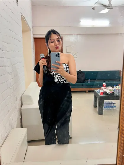 A mirror selfie in my green room, holding my mic, getting ready for a big show.
