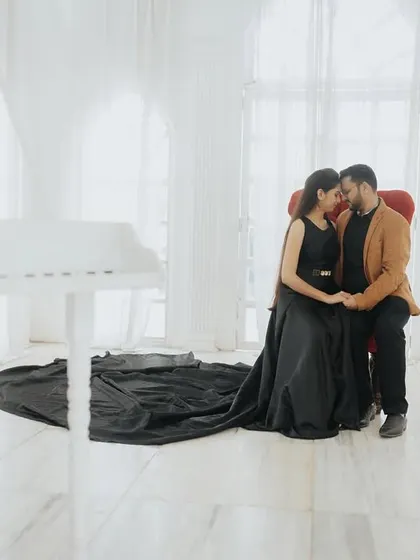 An intimate moment in a white studio, with a grand piano and the bride's long dress creating a romantic and elegant scene.