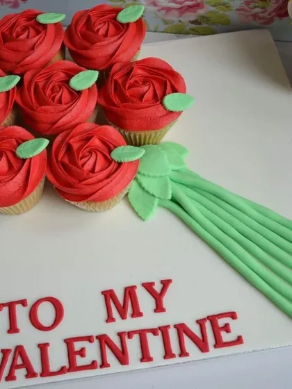 A creative and delicious gift, this cupcake bouquet features six vanilla cupcakes frosted to look like a bouquet of red roses, with "To My Valentine" written in icing.