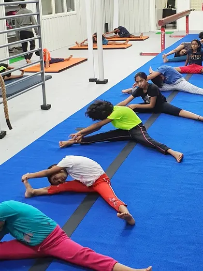 Students work on their pancake and straddle stretches, which are crucial for developing hip flexibility for splits and leaps.