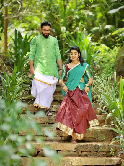 A candid shot of a couple descending a stone staircase in a lush garden, capturing a natural moment during their pre-wedding shoot.