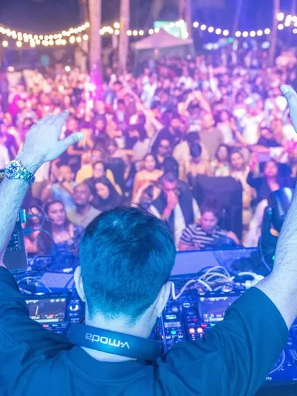 Another view from behind the decks in Mauritius, with my hands up, mirroring the energy of the thousands of fans in front of me. This connection is what live music is all about.