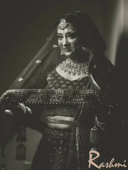 A timeless black and white bridal portrait, capturing the bride's elegance and the texture of her lehenga.