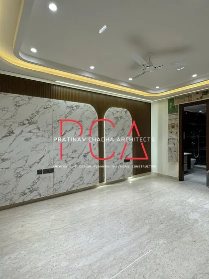 A bedroom in the Vasant Kunj residence featuring a large wardrobe with a white marble-finish laminate and organic, curved shapes.