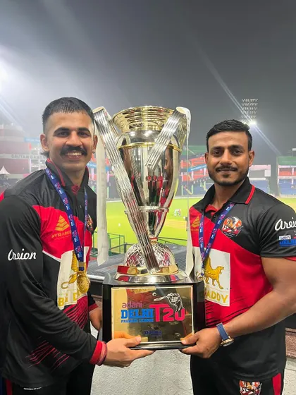 Two members of the coaching staff holding the championship trophy. A team effort in every sense of the word.