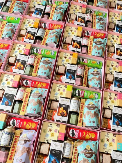 A rainbow of treats! These return favor boxes are packed with a huge variety of goodies, from Lindt and Toblerone chocolates to waffle crisps, protein bars, and instant coffee cubes.