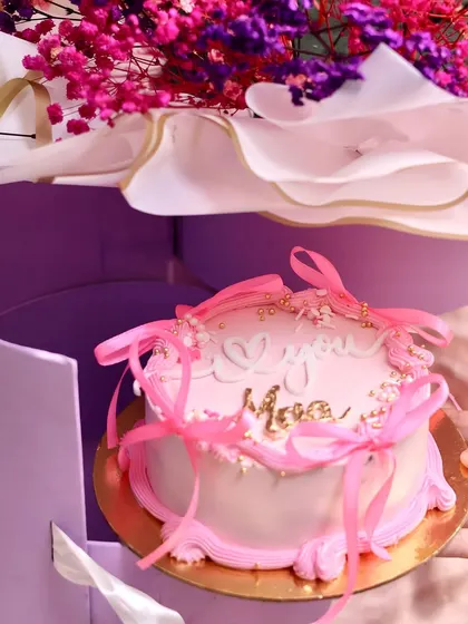 A hand holding the 'I Love You Maa' cake from our Mother's Day surprise box, showcasing the personal and heartfelt nature of this gift.