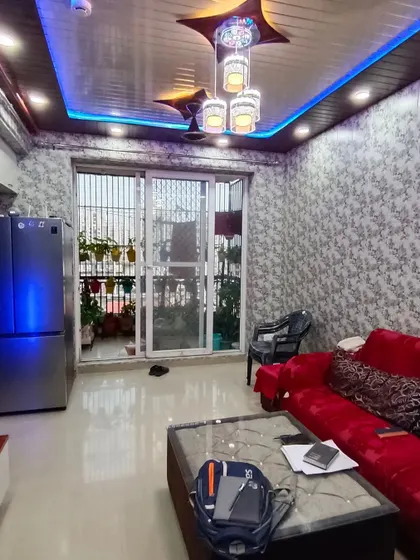 Another angle of the PVC-paneled living room, showing the sliding door to the balcony.