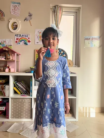 A beautiful fairy with a blue and pink dress. This little artist is so happy with her creation.