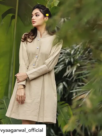 A full-length view of Divya Agarwal in our beige structured tunic dress. This shot highlights the tailored fit and the unique puff sleeves, demonstrating a perfect blend of comfort and style.