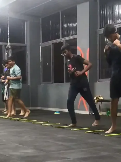 Members working on their boxing footwork using an agility ladder. Quick feet and a solid stance are the foundation of a good boxer.