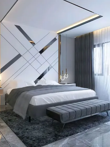 A modern bedroom with a striking geometric accent wall in black and white. The clean lines of the furniture and the neutral color scheme are complemented by sheer curtains that allow for soft, natural light.
