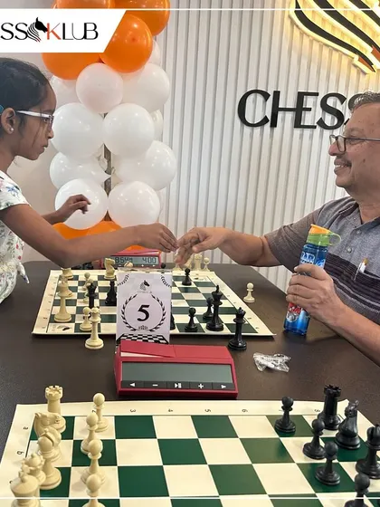 A friendly match between a young girl and an adult player at our JP Nagar opening, showing the cross-generational appeal of our chess community.