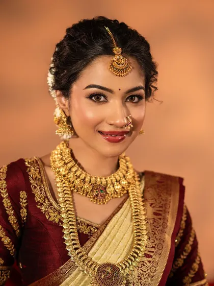 This traditional temple jewellery set features a beautiful coin necklace and matching choker, perfect for a classic South Indian bridal look. The antique gold finish adds a touch of heritage.