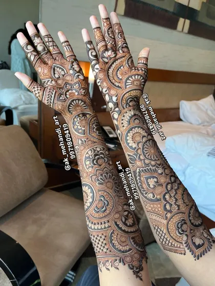A stunning full bridal design for a bride, showcasing intricate patterns that extend all the way up the forearms.
