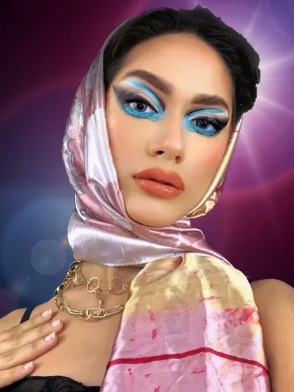Bringing back the vibe of the 1950s. This look combines a vintage-style headscarf with a modern, bold blue graphic eye, creating a unique fusion of eras.