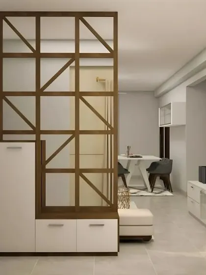 A geometric wooden partition provides a semi-private screen between the entryway and the dining area. The integrated shoe cabinet offers practical storage without compromising on style.